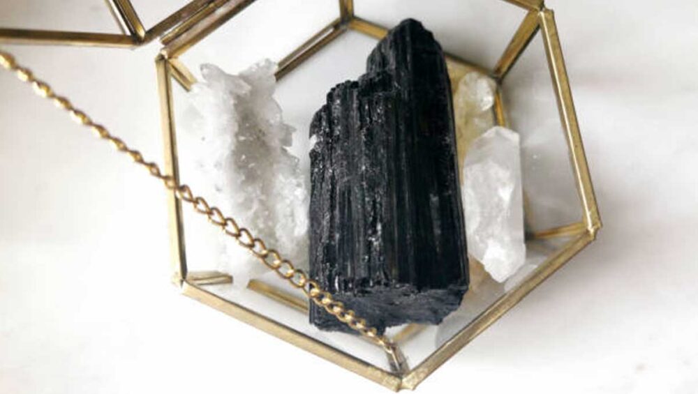 black tourmaline crystal in a glass brass box with clear quartz