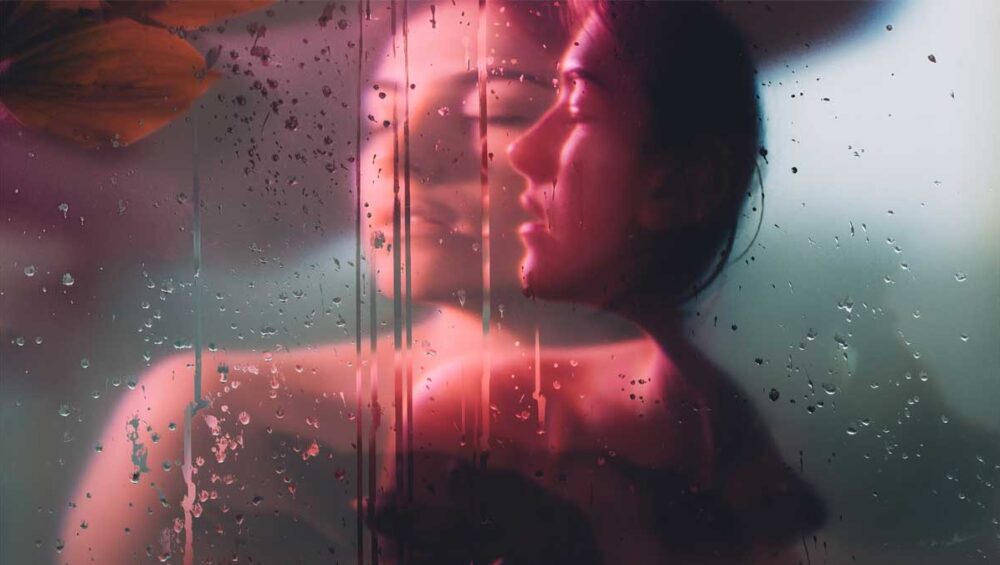 blurred reflection of a woman behind rain-streaked glass symbolizing distorted perception and emotional confusion