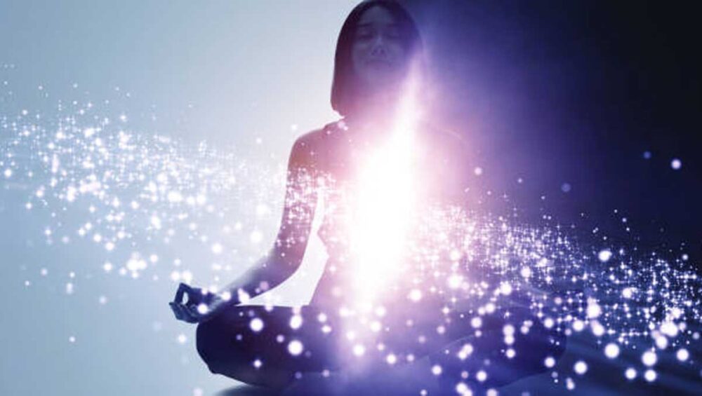 woman meditating with glowing energy light symbolizing empath intuition and protection
