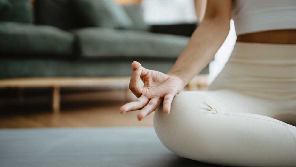 woman meditating indoors practicing mindfulness for anxiety