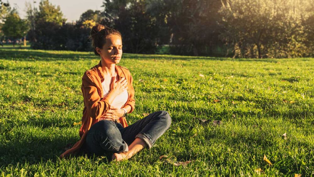 woman practicing self-care and mindfulness in nature to prevent emotional exhaustion