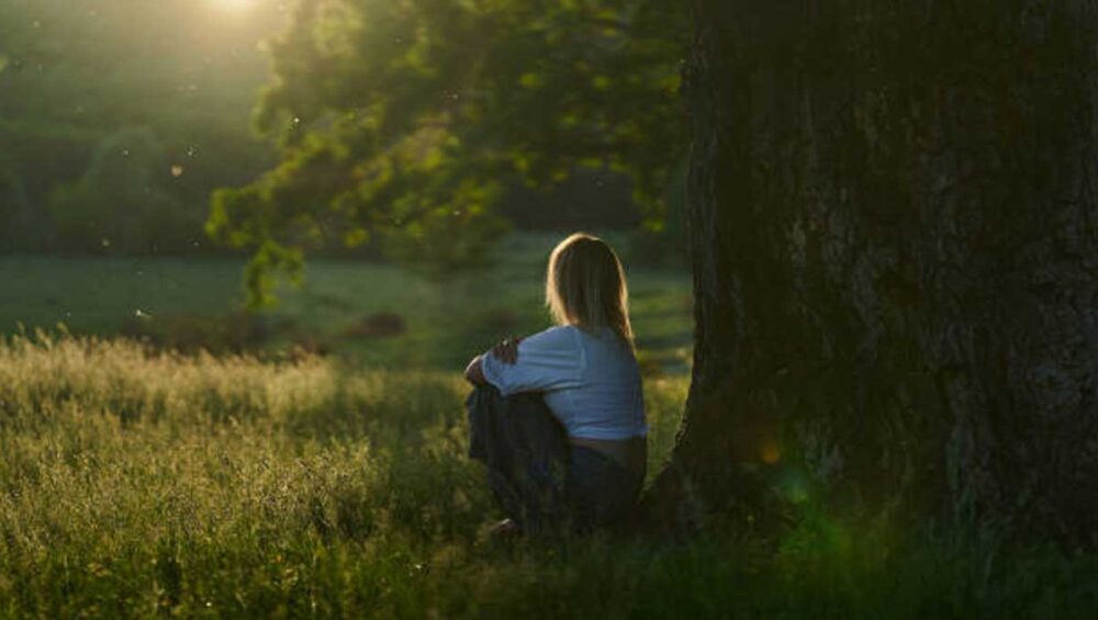Person sitting alone in nature to rest and recover from empathy burnout