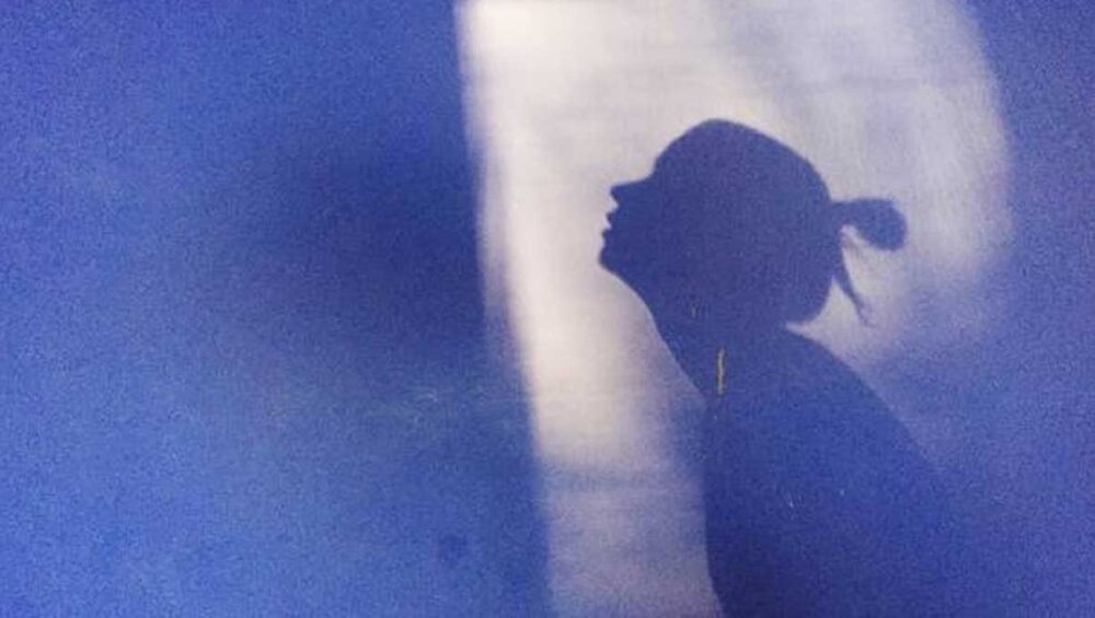 Silhouette of a person in soft light, symbolizing family emotional dynamics and the inner voice shaped by early experiences