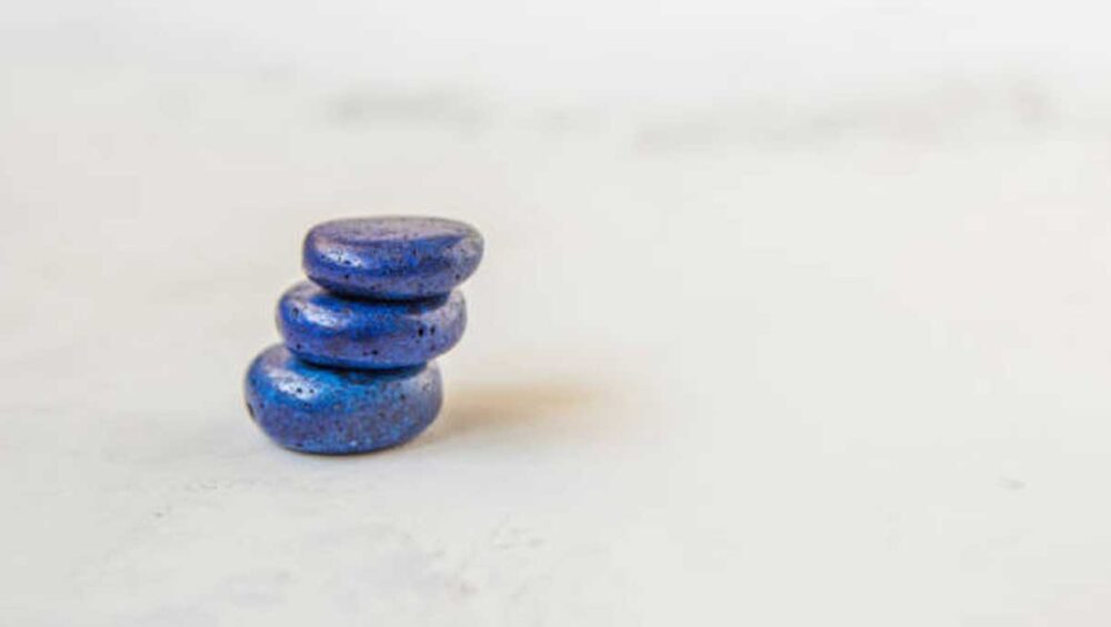 three stacked lapis lazuli stones on a light background symbolizing clarity and calm
