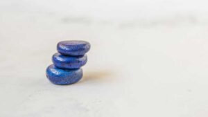 three stacked lapis lazuli stones on a light background symbolizing clarity and calm