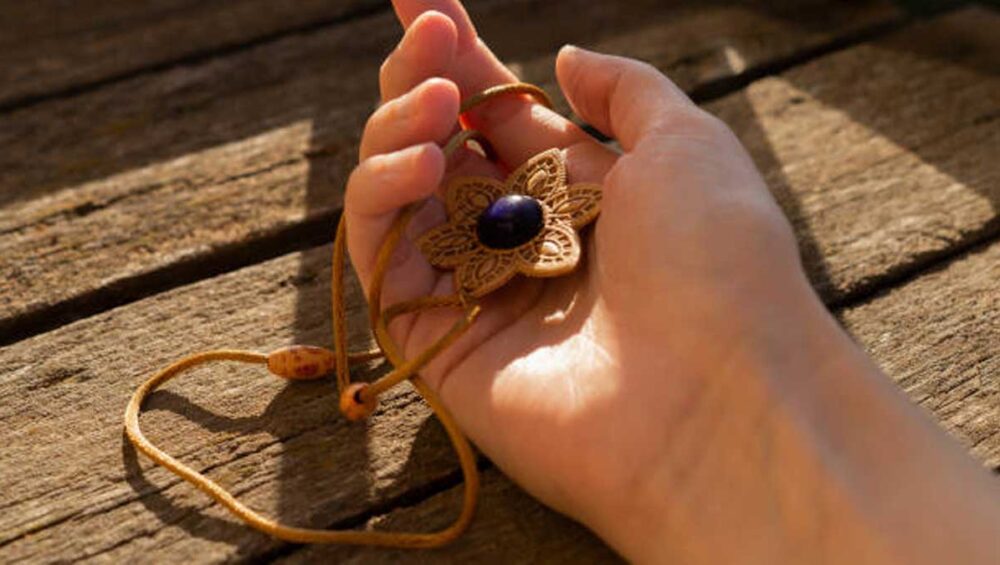 hand holding a lapis lazuli meditation pendant in warm sunlight