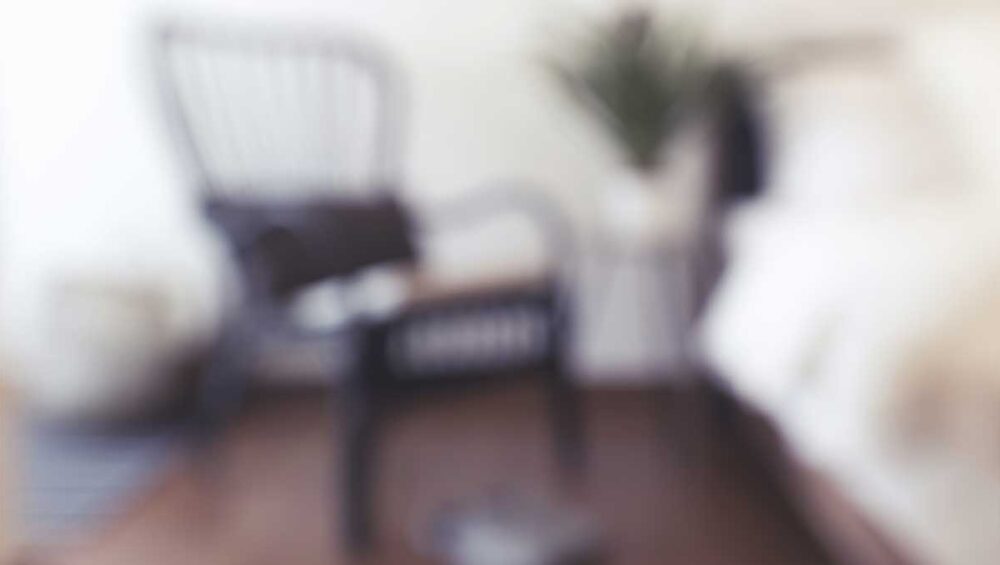 blurred empty chair in a quiet bedroom symbolizing emotional distance