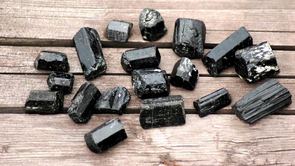 black tourmaline stones arranged on wood for grounding and protection