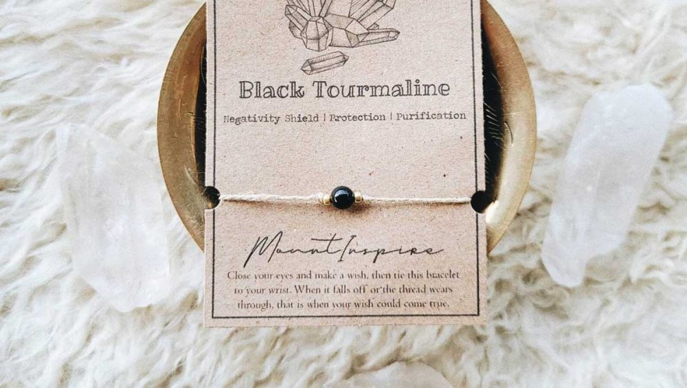 Black tourmaline bracelet displayed on a neutral card with soft natural textures