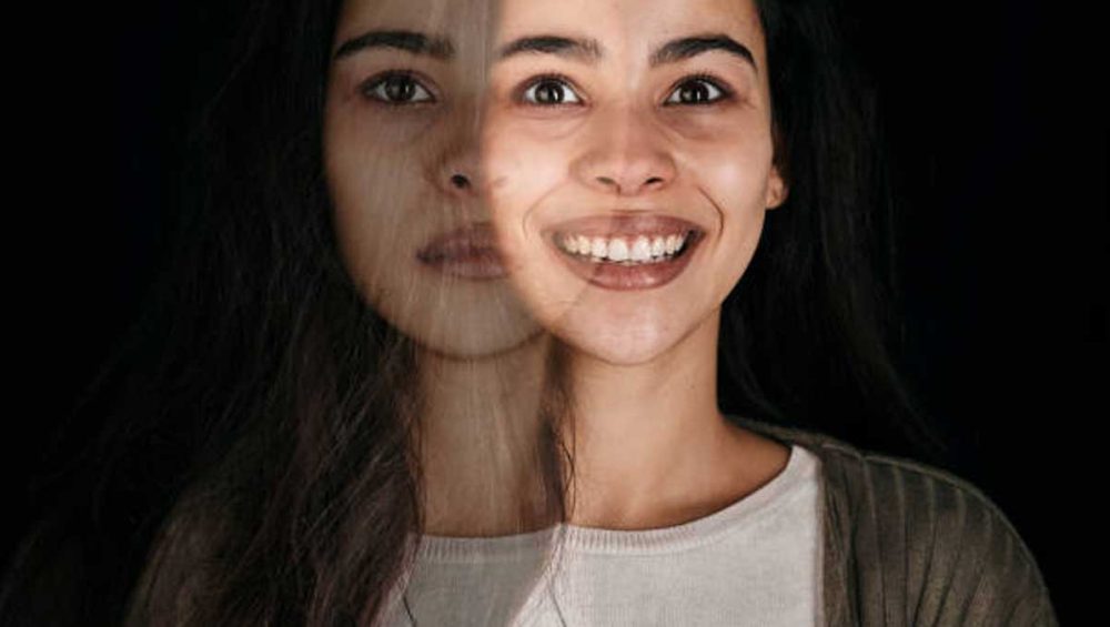 Portrait of a woman with a smiling face blended with a shadowed, serious expression.