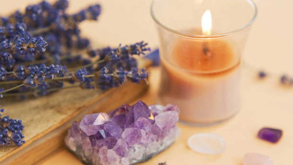 amethyst crystal with candlelight and lavender on a bedside surface symbolizing calm sleep and dreams