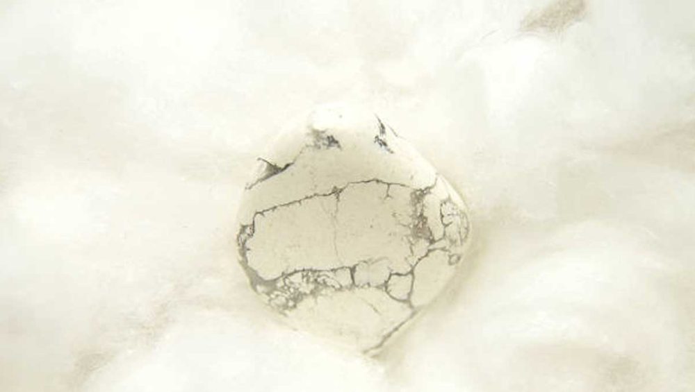 white howlite stone resting on soft cotton, symbolizing calm and sleep support