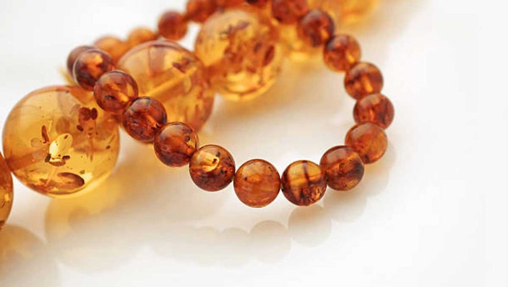 close-up of polished amber bead bracelet with warm golden and honey tones